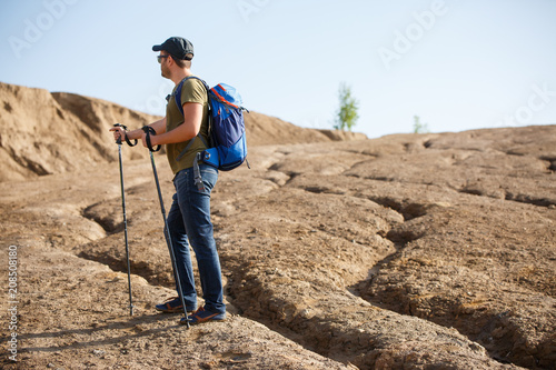 Image of side athlete with backpack and walking sticks