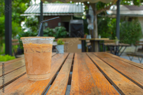 Iced coffee on a wooden table in the garden.