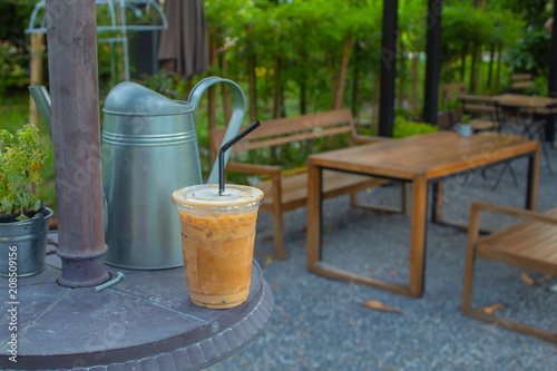 Iced coffee on a wooden table in the garden.