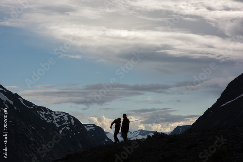 Two men throwing rocks among mountains in the sunset © Tess Lundin