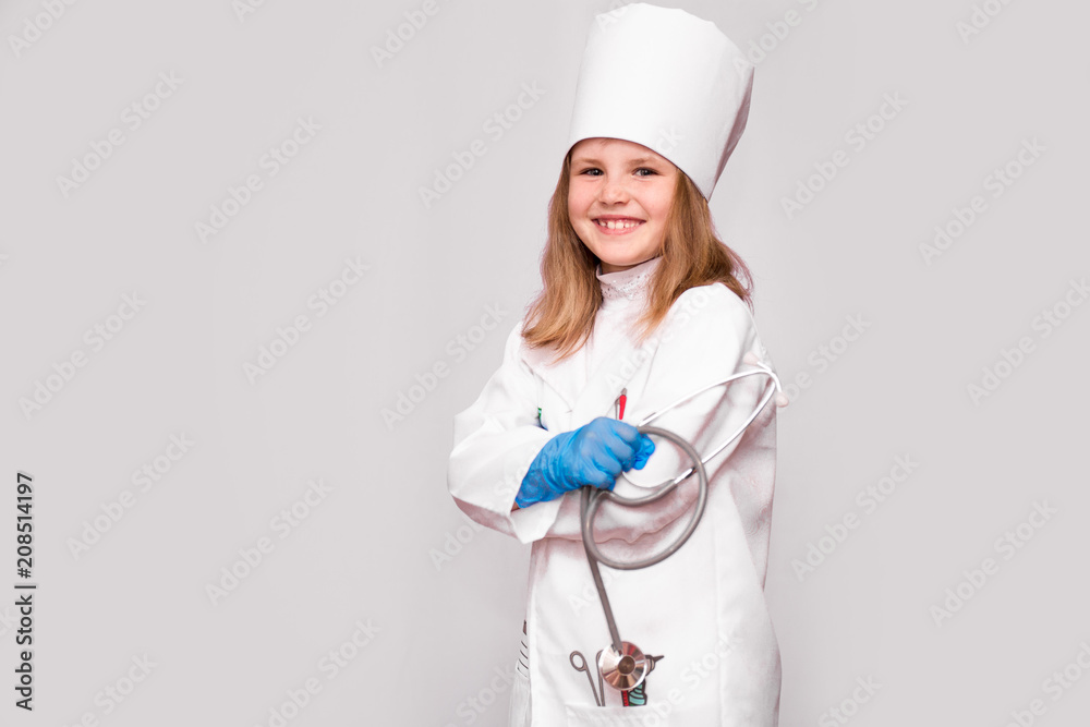 Smiling little girl in medical uniform and blue gloves looking at camera isolated on white Smiling little girl in medical uniform and blue gloves looking at camera isolated on white