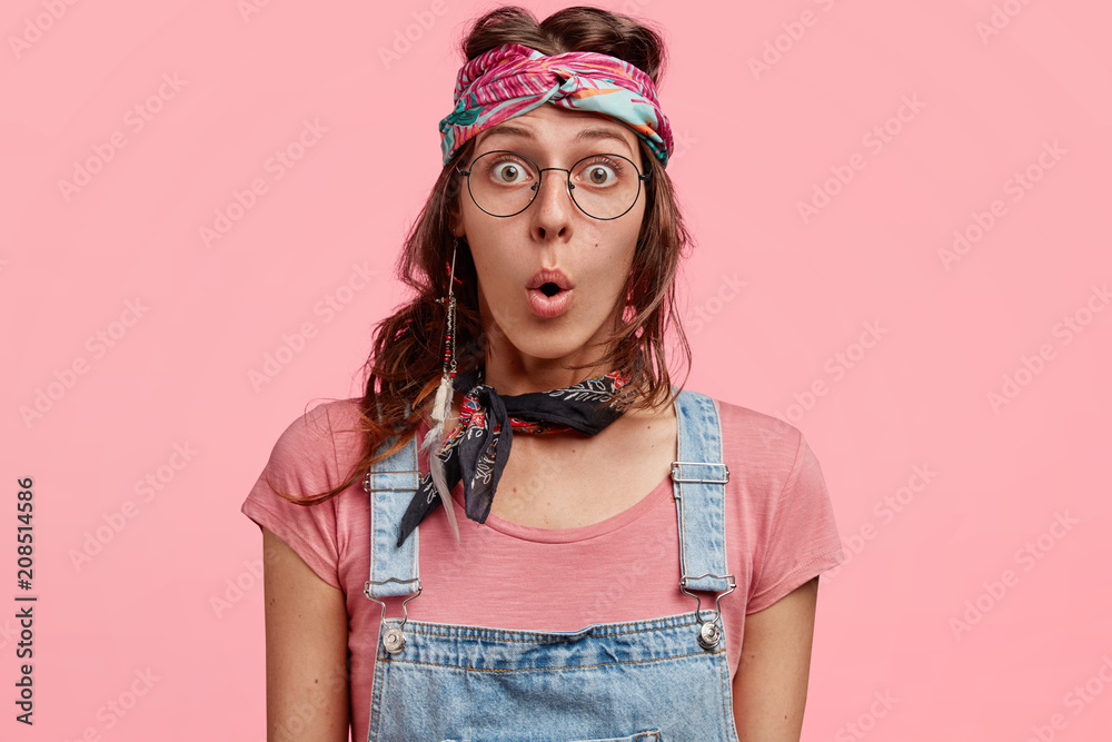Surprised Lovely Hippie Woman Recieves Stunned News Wears Stylish Bandana And Denim Overalls Poses Against Pink Background Hippy Woman Has Shocked Expression Doesn T Expect See Something Stock Photo Adobe Stock