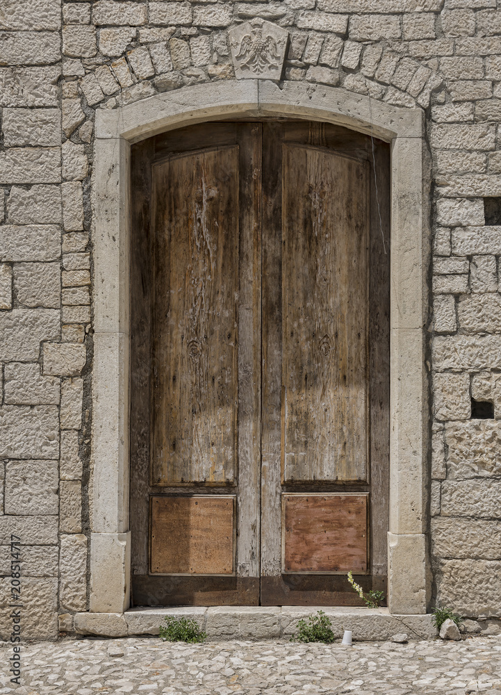 Fototapeta premium Medieval wooden door, adorned with stone