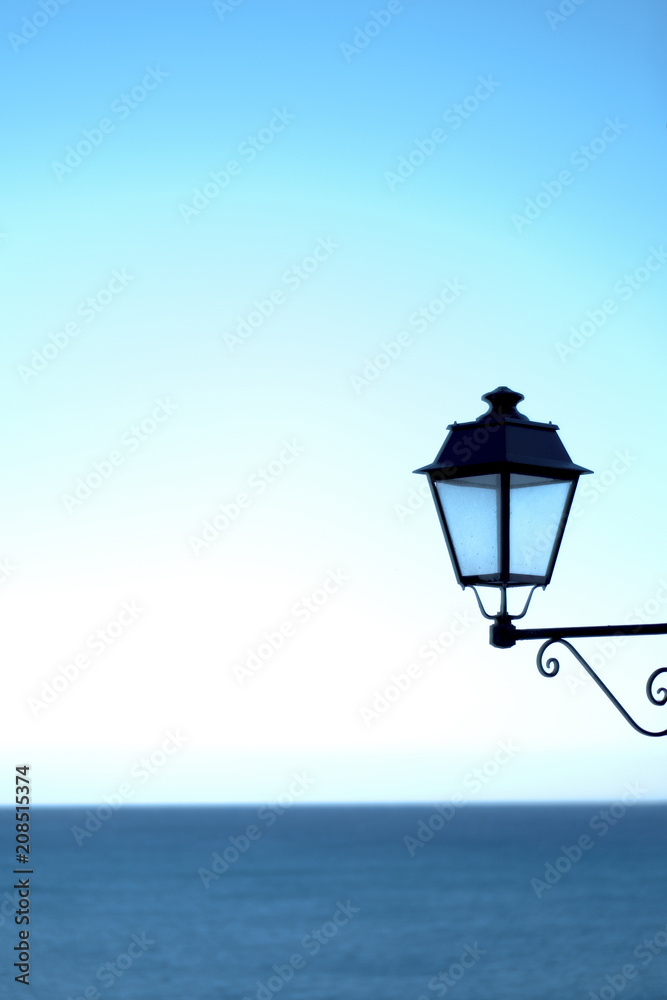 un lampadaire murale avec la mer méditerranée en arrière plan 