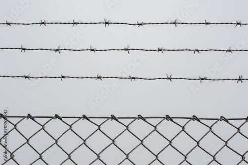 A fence against the white winter sky