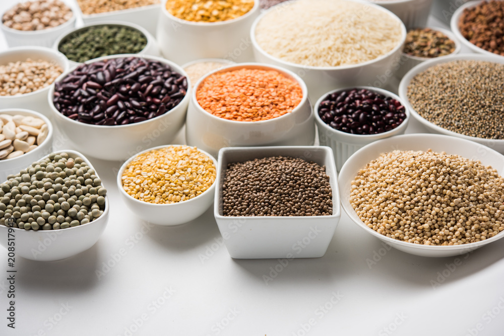 Uncooked pulses,grains and seeds in White bowls over white background. selective focus