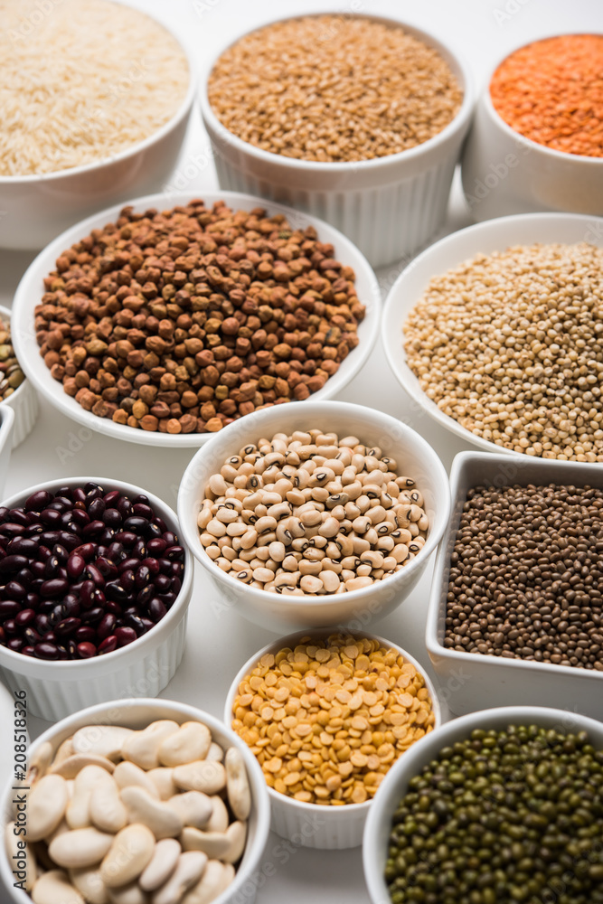 Uncooked pulses,grains and seeds in White bowls over white background. selective focus