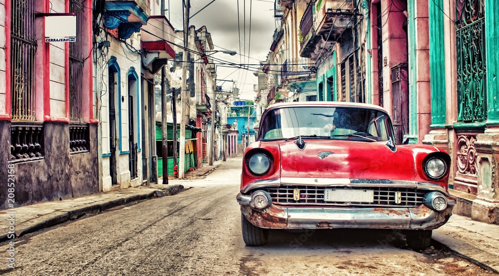 Fototapeta Old red Chevrolet car parked in a street of havana