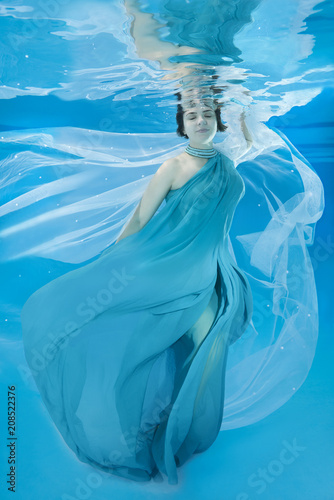 beautiful woman in a long dress posing under water (for the calendar, winter, February)