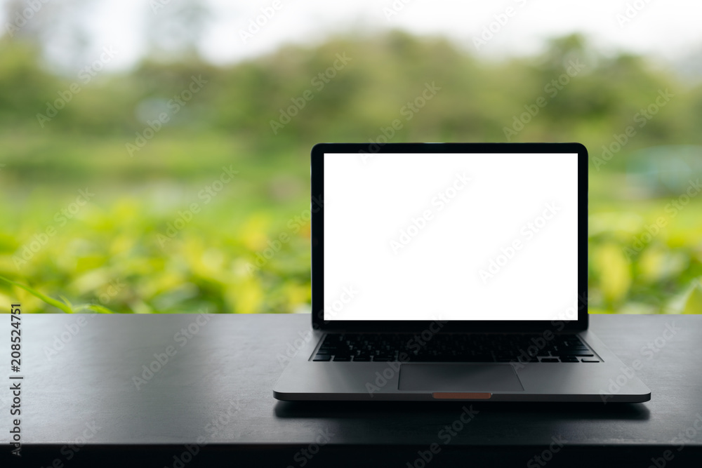 Laptop with blank screen on table, Conceptual workspace, Laptop computer with blank white screen on table, Green blurred background. Laptop with blank screen on table, Conceptual workspace, Laptop computer with blank white screen on table, Green blurred background.