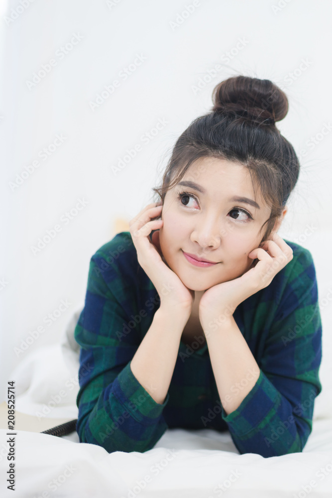 Cheerful woman miss somebody and lying on the bed at home. Beautiful Asian girl smile on bed Cheerful woman miss somebody and lying on the bed at home. Beautiful Asian girl smile on bed