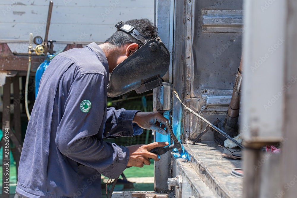 Welding in the industry by highly skilled technicians and wearing a safety mask. Welding in the industry by highly skilled technicians and wearing a safety mask.