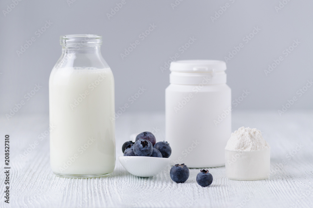 milk products and blueberrys on the table and gray background