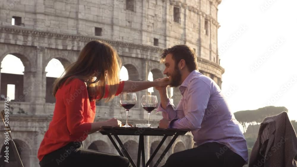 Romantic elegant couple in love sitting at restaurant table in front of ...
