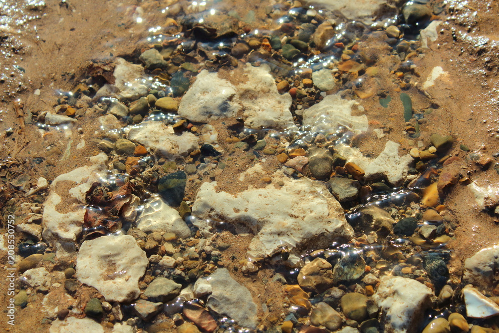 Transparent spring trickle. Close-up. Background. Transparent spring trickle. Close-up. Background.