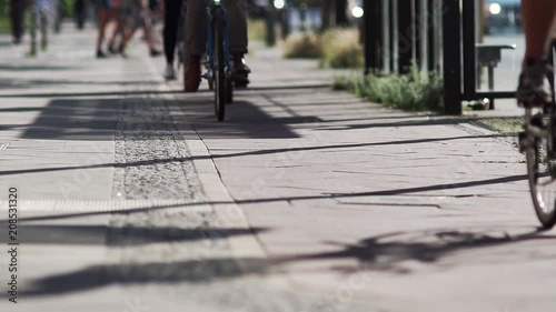 Slow Motion Shot Of Multiple Bicycle Riders Cycling On A Bicycle Lane On The Sidewalk In Berlin.