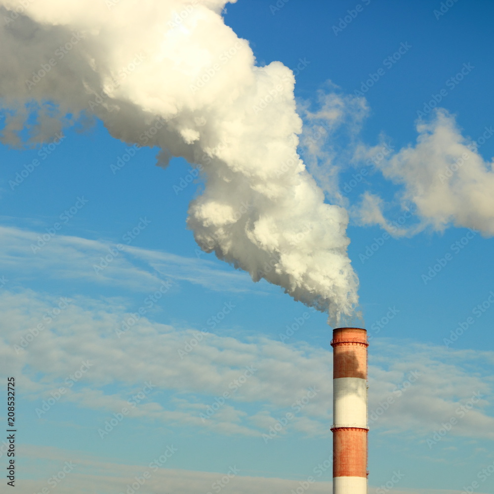 Industry, industry and ecology - white smoke from the red-white pipe of the plant (chemical plant power plant), thermal power plant against the blue clear sky