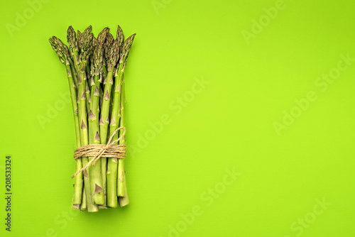 Food background asparagus flat lay pattern. bunch of fresh green asparagus on green background, top view. photo