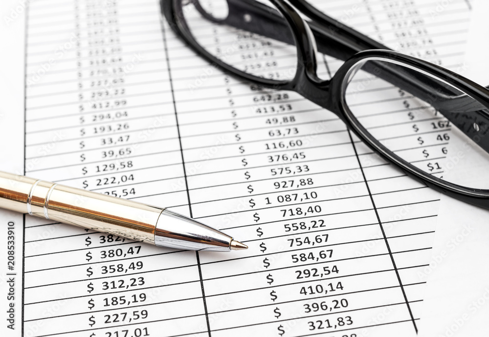 Pen and eyeglasses on the documents with financial data. Business concept. Pen and eyeglasses on the documents with financial data. Business concept.