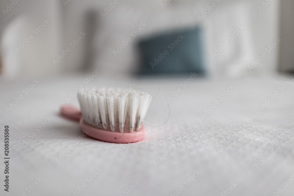 Pink brush hairstyle on a white sheet bed Pink brush hairstyle on a white sheet bed