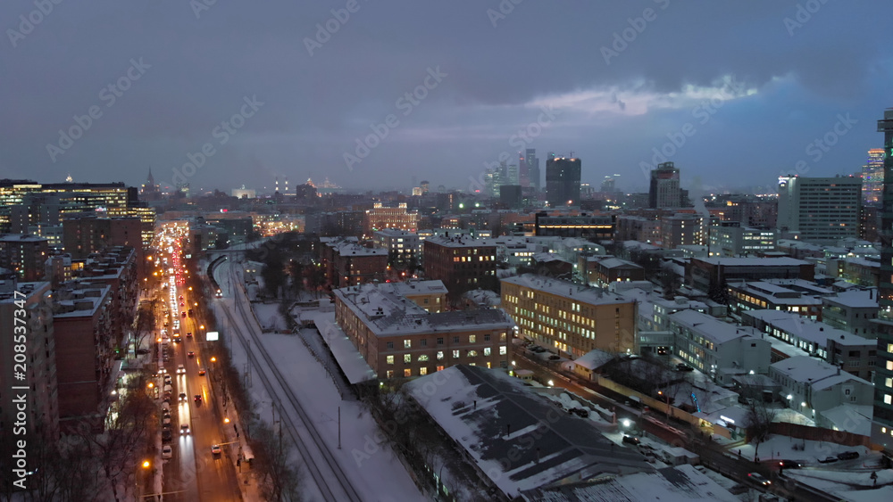 Moscow night aerial shot along railways, late evening Russian capital cityscape street view.