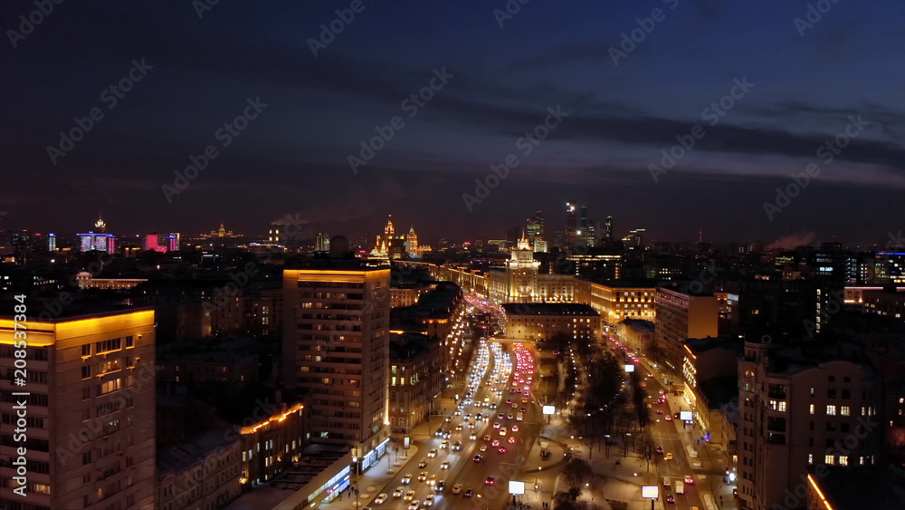 Aerial shooting of Moscow Garden Ring at night. City lights and intensive traffic on the highway. Panoramic cityscape with illuminated buildings.