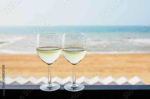 Two glasses of white wine with Atlantic coast beach in background