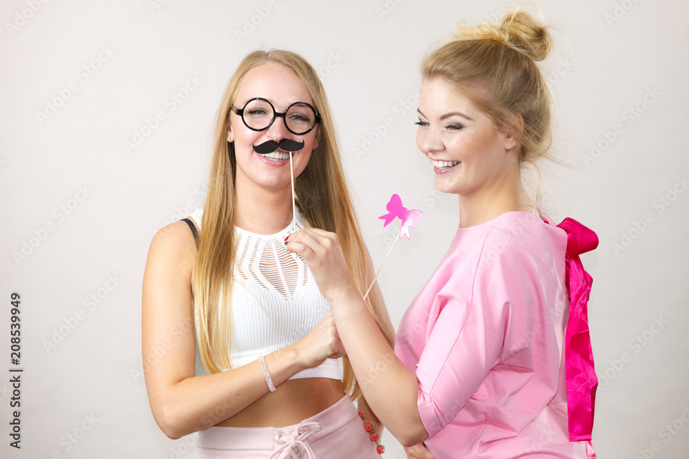 Two women holding carnival accessories Two women holding carnival accessories