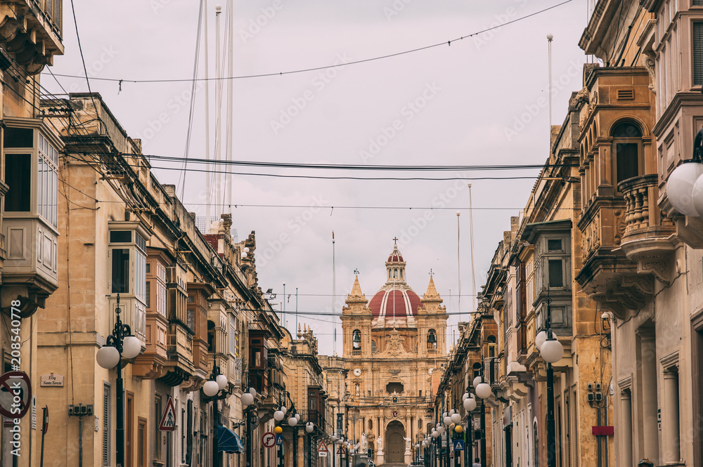 Fototapeta premium Stree view in Zabbar, Zabbar Parish Church, Malta
