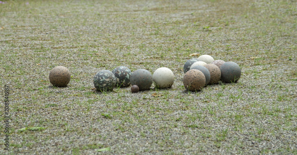 Boules en pierre et un petit cochonnet en bois sur le terrain de pétanque  dans un jardin Stock Photo | Adobe Stock