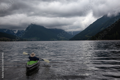 Adventurous Man on a Kayak is enjoying the beautiful Canadian Mountain Landscape. Taken in Jones Lake, near Chilliwack and Hope, East of Vancouver, BC, Canada.