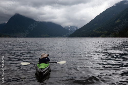 Adventurous Man on a Kayak is enjoying the beautiful Canadian Mountain Landscape. Taken in Jones Lake, near Chilliwack and Hope, East of Vancouver, BC, Canada.