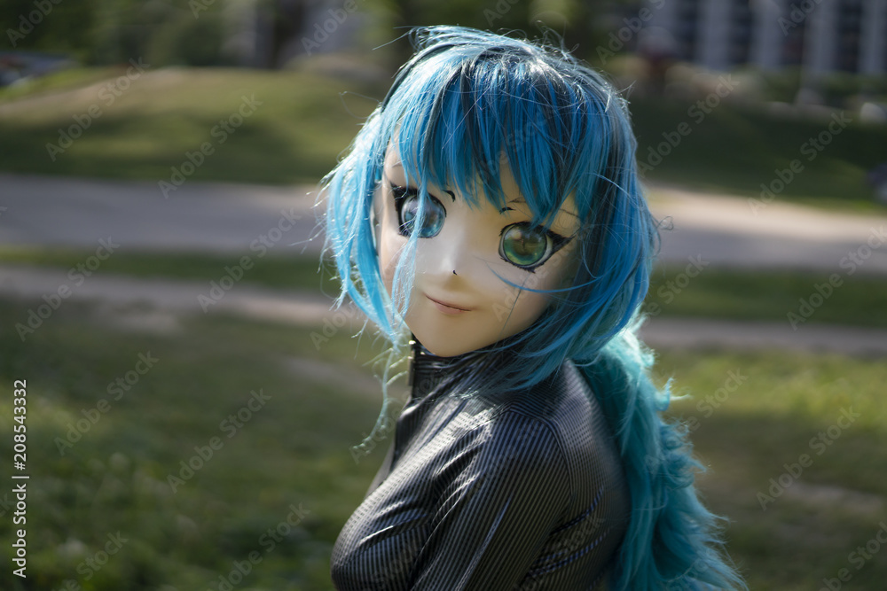 blue-haired anime head girl looking like a big doll wearing latex overalls  walking in the Park Stock Photo | Adobe Stock