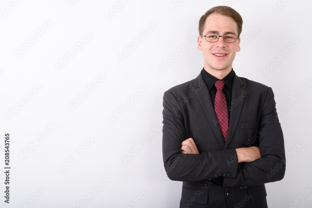 Fototapeta premium Young handsome businessman wearing suit against white background