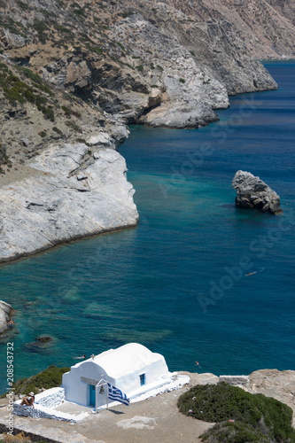 Amorgos, Greece-August 3, 2017.A girl photographed in front of the small entrance of Agia Anna Chapel on Amorgos island, Greece, Cyclades.