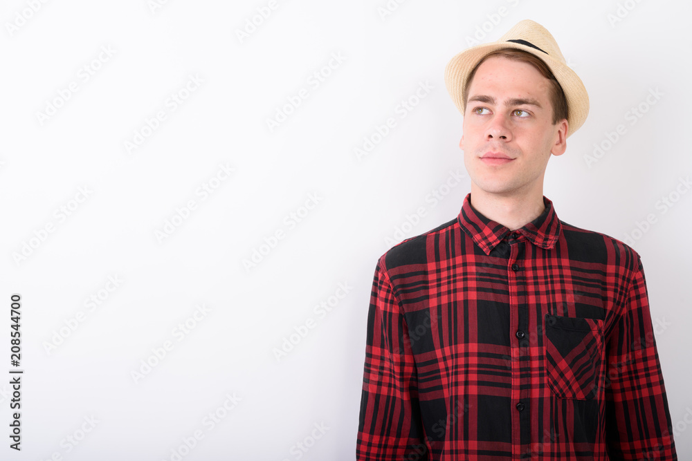 Young handsome tourist man wearing hat against white background
