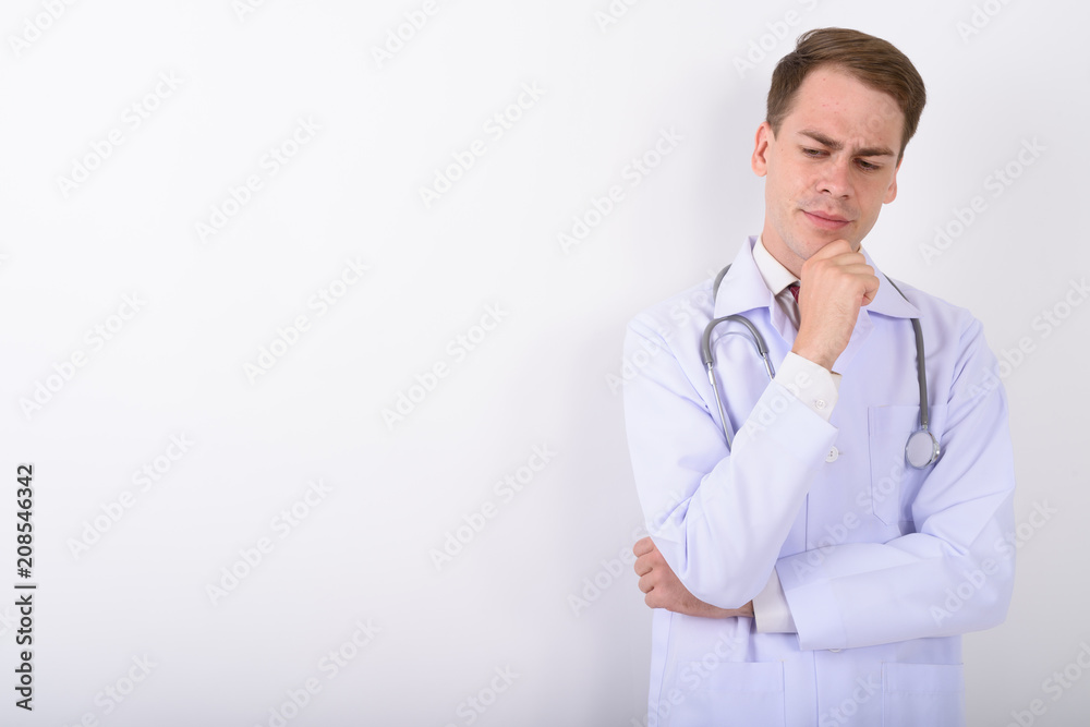 Young handsome man doctor against white background Young handsome man doctor against white background