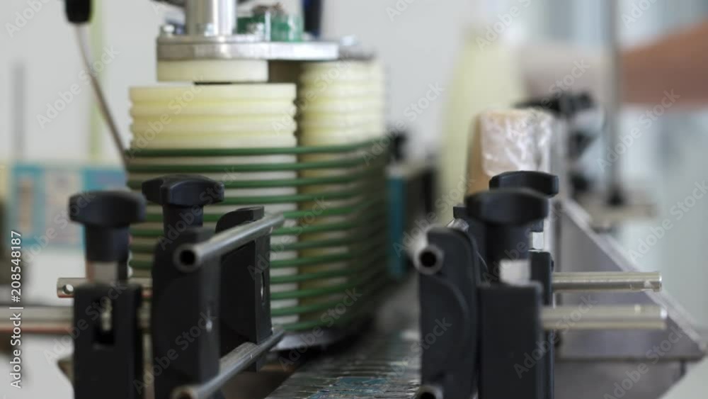 Modern labeling machine at milk production line. Close up packing milk plastic bottles at factory in slow motion Modern labeling machine at milk production line. Close up packing milk plastic bottles at factory in slow motion