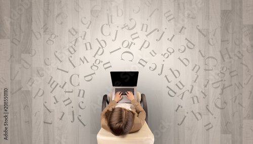 Letters with writer using tablet in a beige chair and an office space 