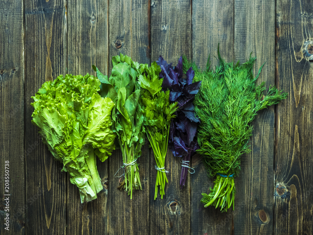 five bunches of asorted herbs on a wooden surface five bunches of asorted herbs on a wooden surface