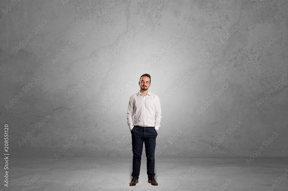 Fototapeta premium Alone handsome businessman standing in a dark empty room