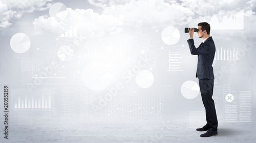 Businessman looking forward with binoculars cloudy background and graphs, charts around
