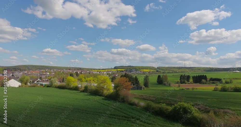 Beautiful small green village from above.Aerial view of a green rural area under blue sky with clouds on a warm summer day. Beautiful small green village from above.Aerial view of a green rural area under blue sky with clouds on a warm summer day.