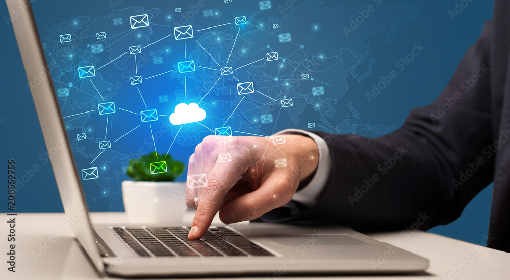 Businessman hand sending a bunch of messages on laptop with cloud computing concept
