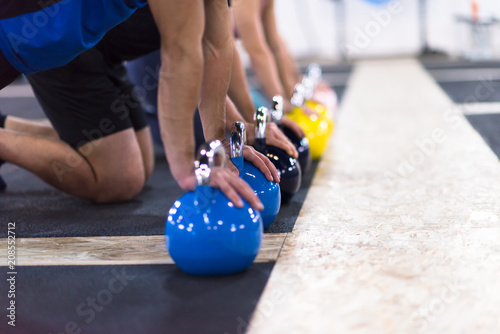 young athletes doing pushups with kettlebells