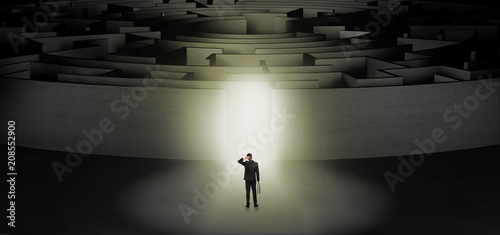 Businessman getting ready to enter a concentric labyrinth with lighted entrance concept  