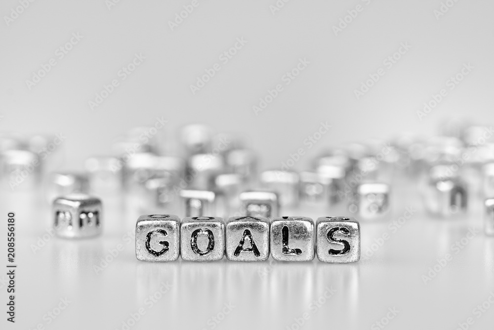 Goals word written on silver cube with black and white bokeh cube word block background Goals word written on silver cube with black and white bokeh cube word block background