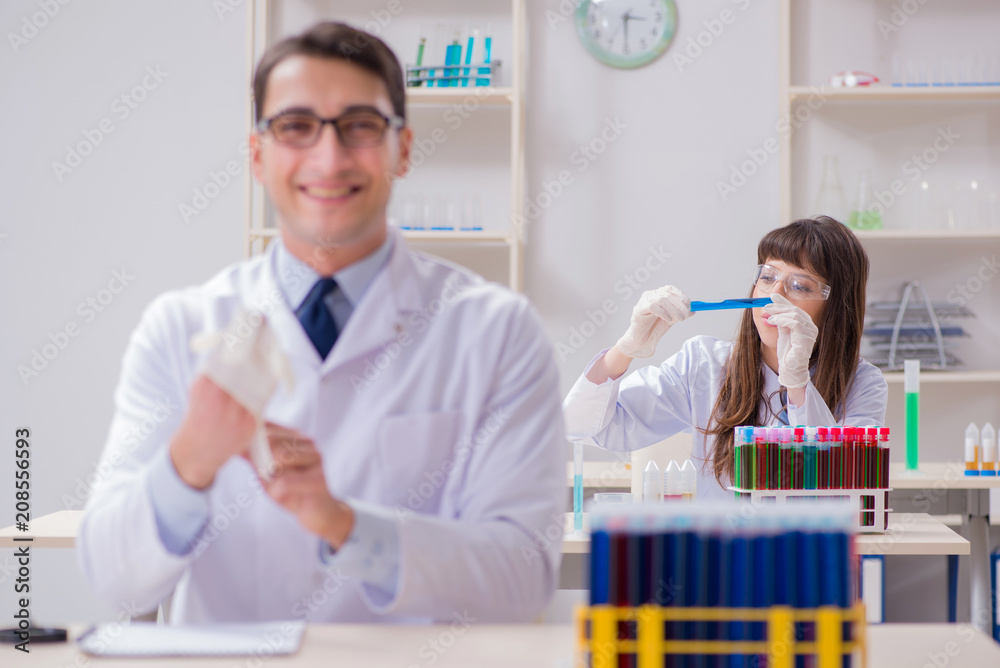 Two chemists working in lab experimenting Two chemists working in lab experimenting