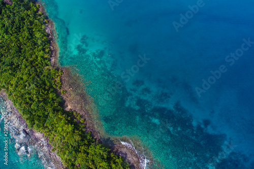 Rocky island sea beach with green tree aerial view