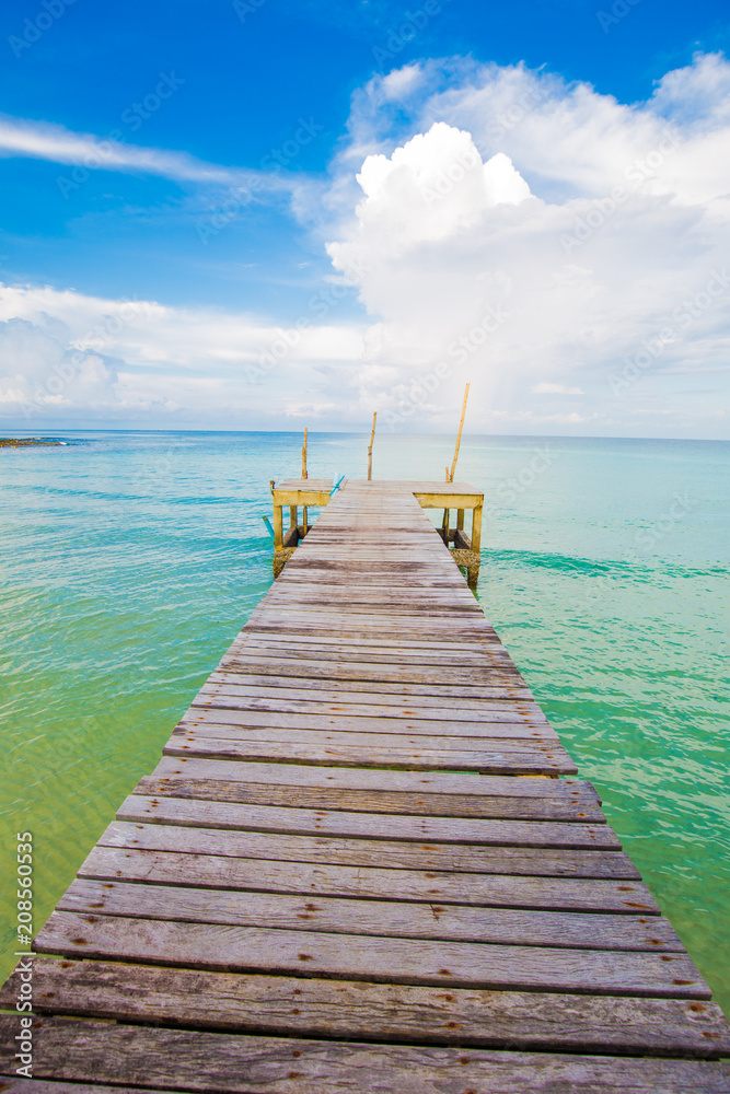 Obraz premium Wooden bridge with blue sky cloud sunrise in the sea